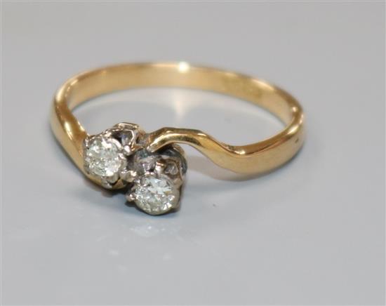 An 18ct gold and two stone diamond crossover ring, size M.